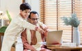 Two people of surprising Indian single father, son twearing traditional clothes, using laptop or notebook, win the game, playing