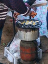 Two people take quial`s eggs that ready to eat out of the stove.