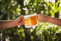 Two people toasting with mugs full of chopp Royalty Free Stock Photo