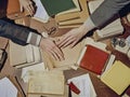 Two people are touching hands on a table with papers and books Royalty Free Stock Photo