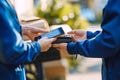 Two people using mobile devices and a card reader for a contactless payment transaction during a delivery service Royalty Free Stock Photo
