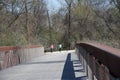 Two People walk a dog over the Wolf River bridge.