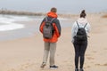Two people walking beach observing ocean wearing backpacks Royalty Free Stock Photo