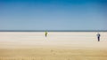 Two people walking to the sea at a wide beach