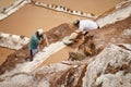 Two people working together at Salina de Maras in Peru