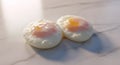 Two perfectly cooked sunnysideup eggs on a light surface Royalty Free Stock Photo