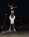 Two performance artists balance on top of a bridge