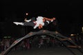 Two performance artists balance on top of a bridge