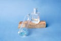 Two perfume bottles are placed on a wooden surface against a blue background, creating a balanced and elegant composition Royalty Free Stock Photo