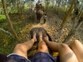 Two person feet on top of elephant