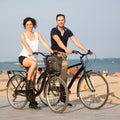 Two persons cycling on the coast