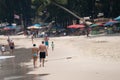 Two persons - young women and older man walk on sand beach keeping hands along the water. Sunny tropical day at Bang Thao beach