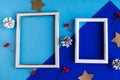 Two photo frames and Christmas decorations on color geometric background. Royalty Free Stock Photo