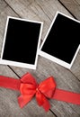 Two photo frames over wooden background with red bow Royalty Free Stock Photo