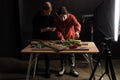 Two photographers making food composition for commercial photography on smartphone