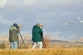 Two photographers with telephoto lens photograph Sandhill cranes and snow geese at the Bosque del Apache National Wildlife Royalty Free Stock Photo