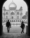 Two photography student walking with camera trough the main gate,entrance of safdarjung tomb memorial at winter morning black and