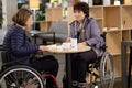 Two physically challenged women in a cafe Royalty Free Stock Photo