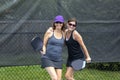 Two pickleball players posing with paddles