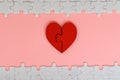 Two piece red jigsaw love heart with white puzzle on pink background Royalty Free Stock Photo