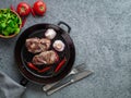 Two pieces of beef fillet, fried steak in a pan. Top view, gray, stone background, blank space for text.