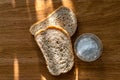 Two pieces of black bran fresh bread with white salt in a salt shaker Royalty Free Stock Photo