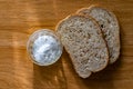 Two pieces of black bran fresh bread with white salt in a salt shaker Royalty Free Stock Photo