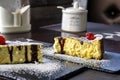 Two pieces of cheesecake with cherries on black stone serving boards on table in cafe. Close-up. Royalty Free Stock Photo