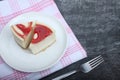 Two pieces of cheesecake on a plate on red and white napkin on black wooden background flat lay Royalty Free Stock Photo