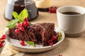Two pieces of chocolate cake brownie decorated with red currant berries and mint for coffee on beige textured background Royalty Free Stock Photo