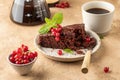 Two pieces of chocolate cake brownie decorated with red currant berries and mint for coffee on beige textured background Royalty Free Stock Photo