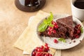 Two pieces of chocolate cake brownie decorated with red currant berries and mint for coffee on beige textured background Royalty Free Stock Photo