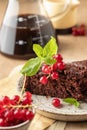 Two pieces of chocolate cake brownie decorated with red currant berries and mint for coffee on beige textured background Royalty Free Stock Photo