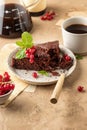 Two pieces of chocolate cake brownie decorated with red currant berries and mint for coffee on beige textured background Royalty Free Stock Photo