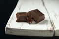 Two pieces of chocolate with star anise on edge of white wooden Provence style table