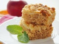 Two pieces of coffeecake on white plate. Fresh crumble pie with streusel topping and mint leaf.