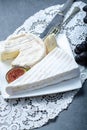 Two pieces of French soft cheeses Brie and Camembert with white mold and strong odor, served with fresh ripe figs and black grapes Royalty Free Stock Photo