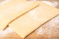 Two pieces of frozen puff pastry on a cutting board close-up