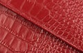 two pieces of genuine red leather with a diagonal seam, like crocodile skin, closeup Royalty Free Stock Photo