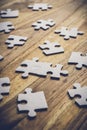 Two pieces of a puzzle connected on a wooden table with many other pieces of the puzzle. Problem Solving Concept Royalty Free Stock Photo