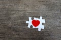 Two pieces of puzzle forming red heart on rustic brown wooden surface, heart on pieces of jigsaw, romantic background for Royalty Free Stock Photo