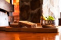 Two pieces of sliced black bread and pickles in a bowl as a snack lie on a wooden board on a table under the sun, bread Royalty Free Stock Photo