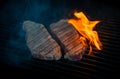 Two pieces of Striploin beef tips on getting grilled on a barbeque grill.GRILLING Royalty Free Stock Photo