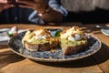 Two pieces of toasted whole rye bread with mashed avocado, poached eggs and sauce. Sandwiches with egg, avocado and sauce Royalty Free Stock Photo