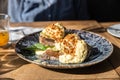 Two pieces of toasted whole rye bread with mashed avocado, poached eggs and sauce. Sandwiches with egg, avocado and sauce Royalty Free Stock Photo