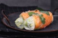 Two pieces of traditional Vietnamese spring rolls fied with salmon, avocado, salad and rice noodles