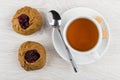 Pies with lingonberry, tea, spoon, sugar on saucer on table Royalty Free Stock Photo