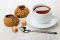 Two pies with lingonberry, tea, sugar cubes, teaspoon on table Royalty Free Stock Photo