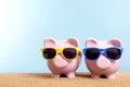 Two piggy banks, beach vacation savings, travel money concept, copy space