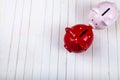 Two pigs piggy banks on a white wooden background